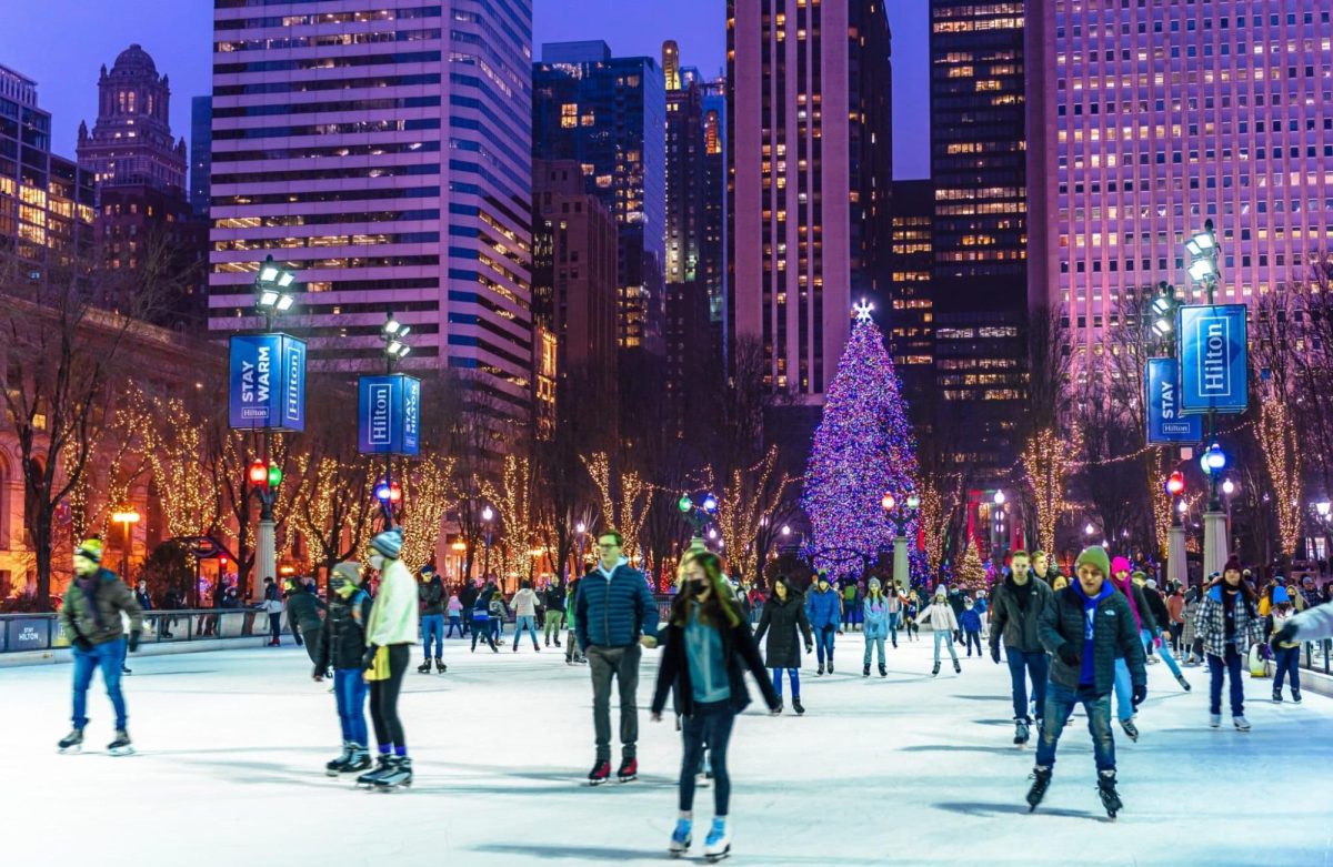 A crowd of people ice skate outside in Millenium Park, Chicago.