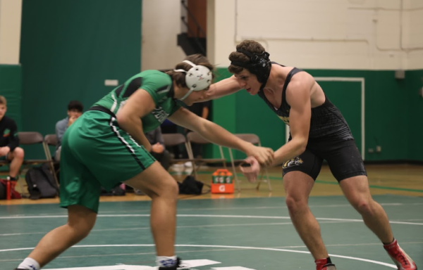 Jacob Zaluska (grey) in a match against Ridgewood's Daniel T (green) at Ridgewood High School. The pair are hunched and in wrestling positions.