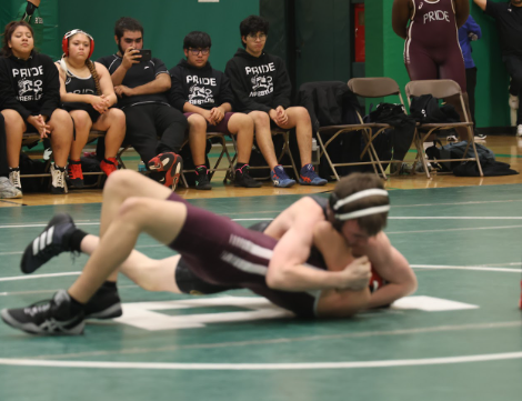 Mikey Aiello (grey) in a match against ITW Speer (maroon) at Ridgewood High School. The two are on the floor wrestling. Aiello is on top of his competitor, seemingly winning.