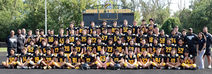 This is the Elmwood Park football team taking in front of the score bored. 
This story covers all the varsity players grade and pistons.