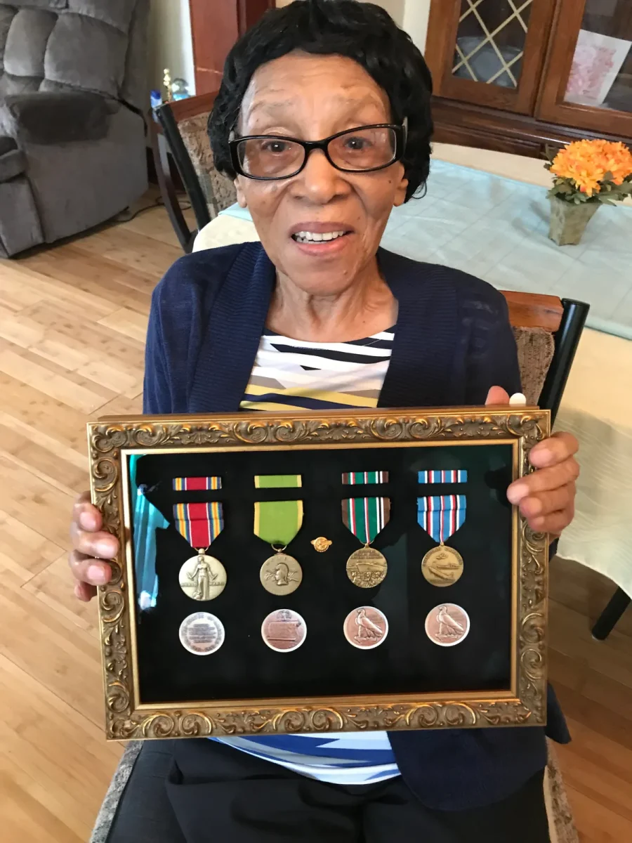 this is a photo of Mae Robertson showing off her medals